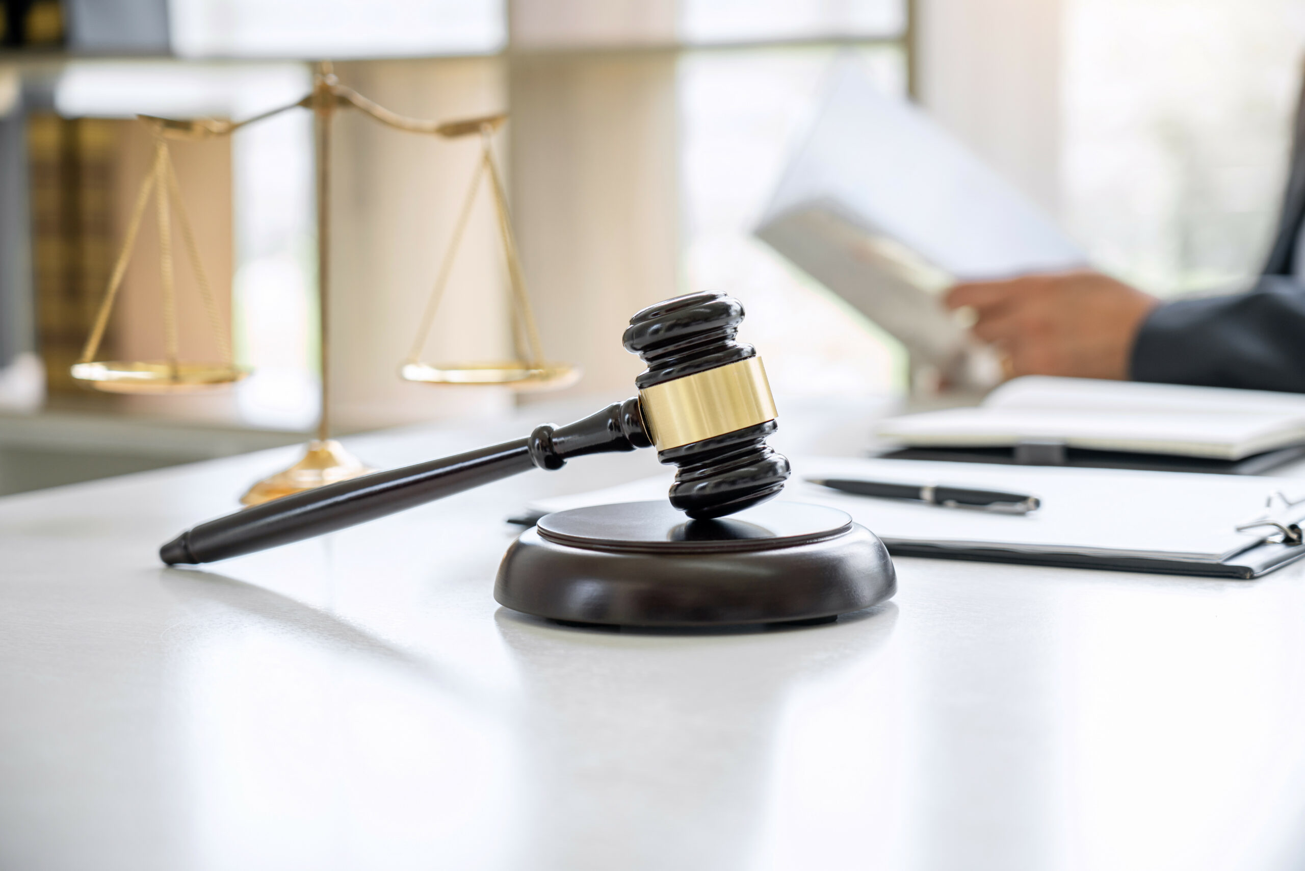 Gavel with person holding documents in background